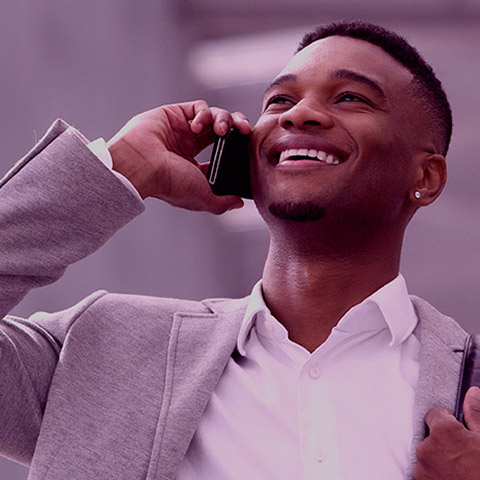 Happy young man talking on mobile phone inside building Happy young man talking on mobile phone inside building